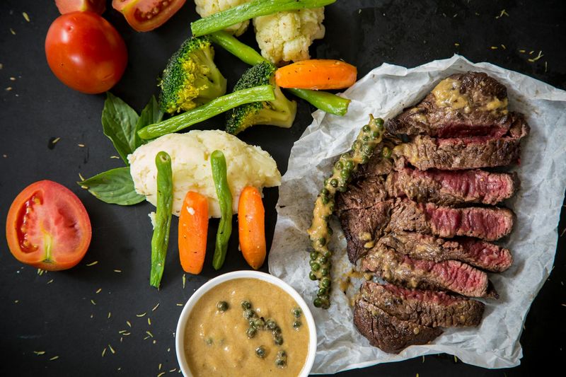 Steak Lovers Paradise: From Raw Cuts to Sizzling Gourmet Plates 7 Peppercorn-Crusted Steak with Creamy Green Pepper Sauce