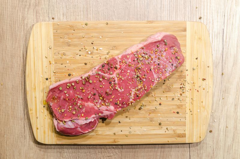 Steak Lovers Paradise: From Raw Cuts to Sizzling Gourmet Plates 9 Seasoned Striploin Steak on Wooden Board