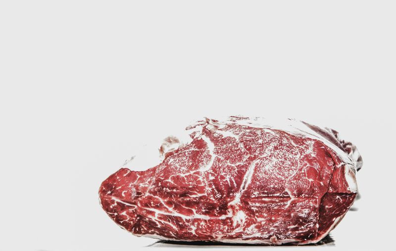 Steak Lovers Paradise: From Raw Cuts to Sizzling Gourmet Plates 10 Raw Marbled Beef Roast on White Background