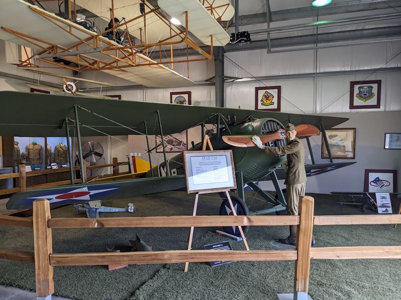 Indoor Museum With Uniforms, Engines, and Historical Photos