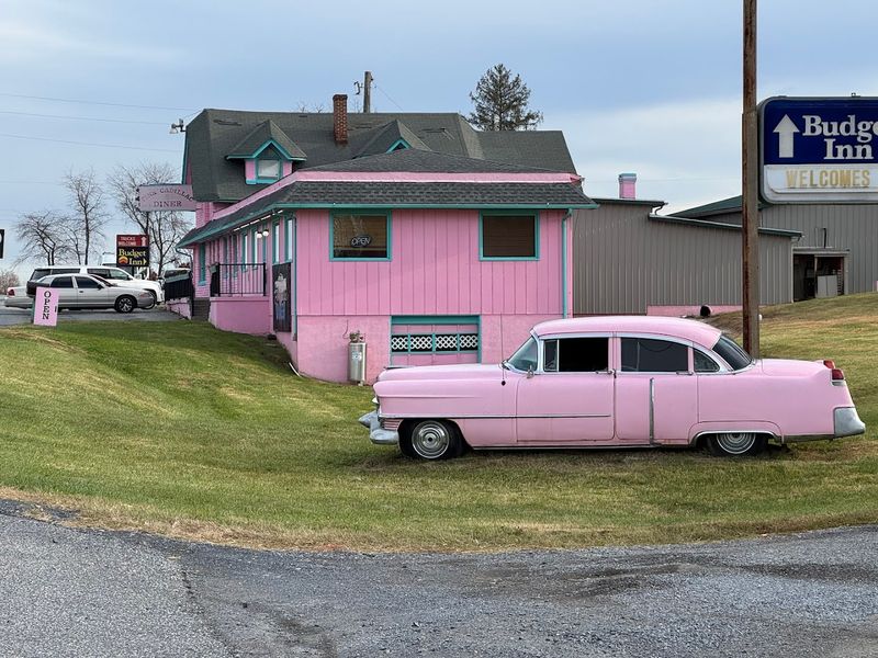 The Iconic Pink Exterior and Vintage Cadillac Out Front