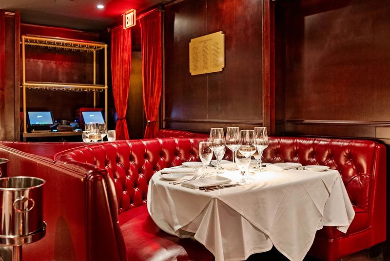 Red Booths, Dark Wood, and Timeless Atmosphere