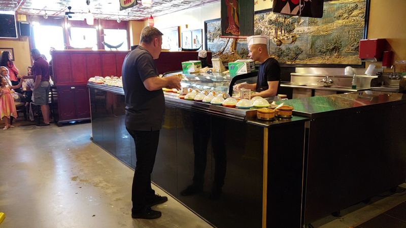The Sushi Chef Working Behind the Conveyor The Sushi Chef Working Behind the Conveyor