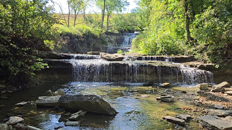 A Short Walk Across the Levee in the Kansas Flint Hills Reaches a Tiered Waterfall Over Rocky Shelves
